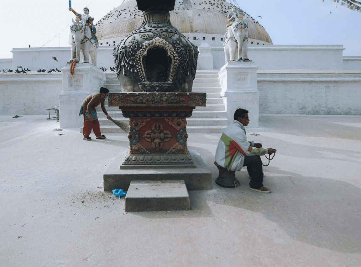 Workers sweeping near temple statue